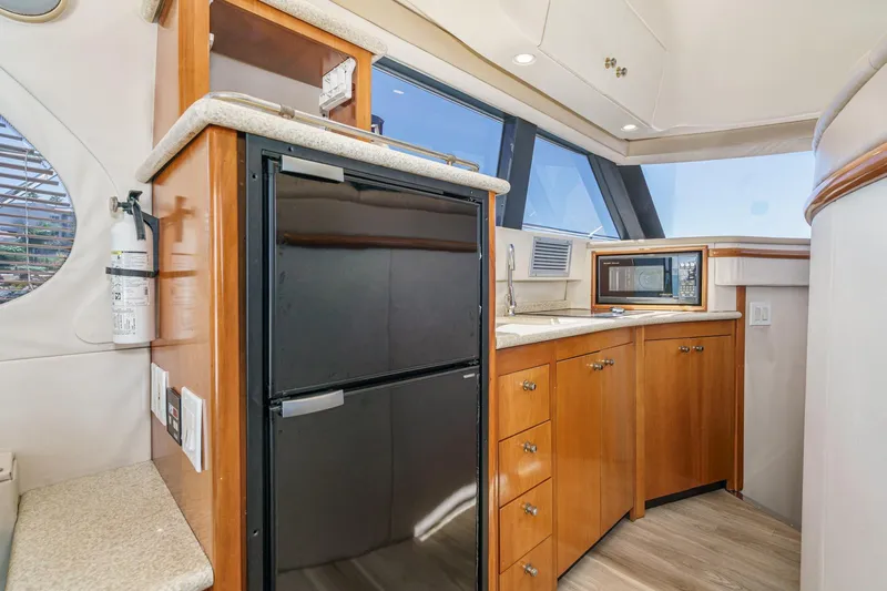 Kathy's Dream Yacht Photos Pics Interior of 2000 Carver 450 Voyager Pilothouse with kitchenette, fridge, and microwave.