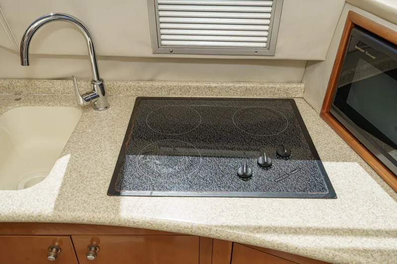 Kathy's Dream Yacht Photos Pics Modern kitchen area in 2000 Carver 450 Voyager Pilothouse with stovetop and sink.