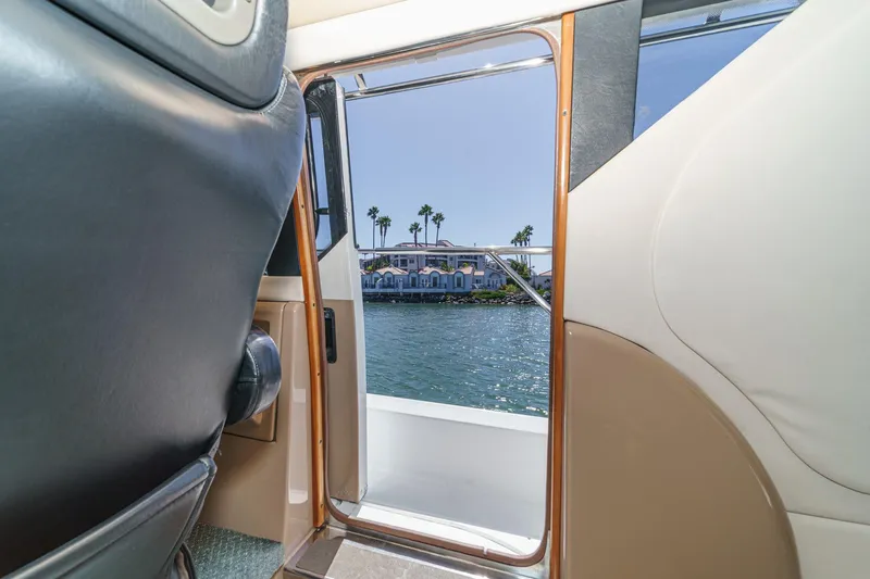 Kathy's Dream Yacht Photos Pics Interior view from a 2000 Carver 450 Voyager Pilothouse, overlooking water and palm trees.