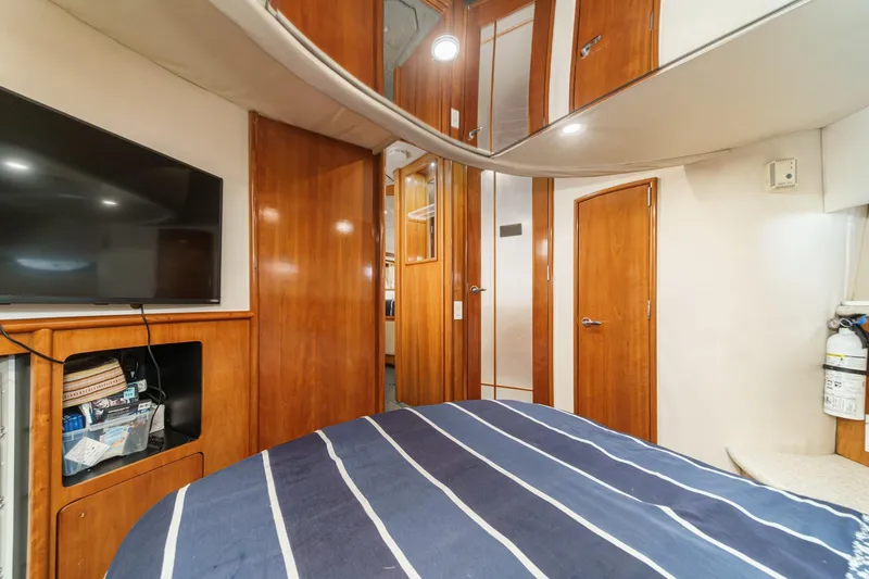 Kathy's Dream Yacht Photos Pics Interior of 2000 Carver 450 Voyager Pilothouse with wood paneling and striped bedding.
