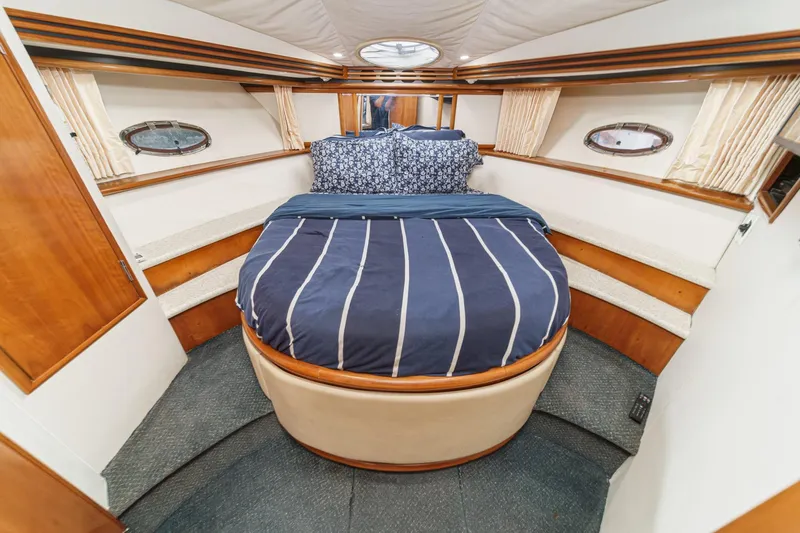 Kathy's Dream Yacht Photos Pics Luxurious 2000 Carver 450 Voyager Pilothouse bedroom with cozy bedding and elegant wood accents.