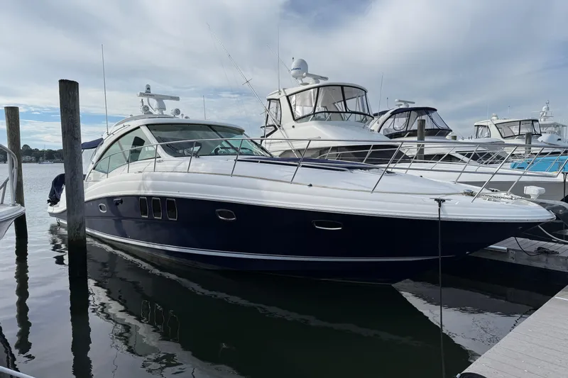 Turn The Page Yacht Photos Pics 2006 Sea Ray 48 Sundancer yacht docked at marina under cloudy sky.