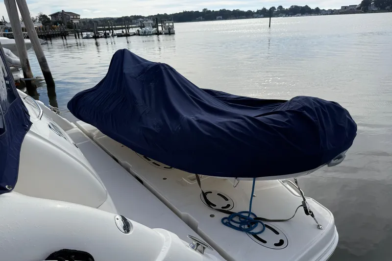 Turn The Page Yacht Photos Pics 2006 Sea Ray 48 Sundancer with covered equipment on deck, docked by calm waters.