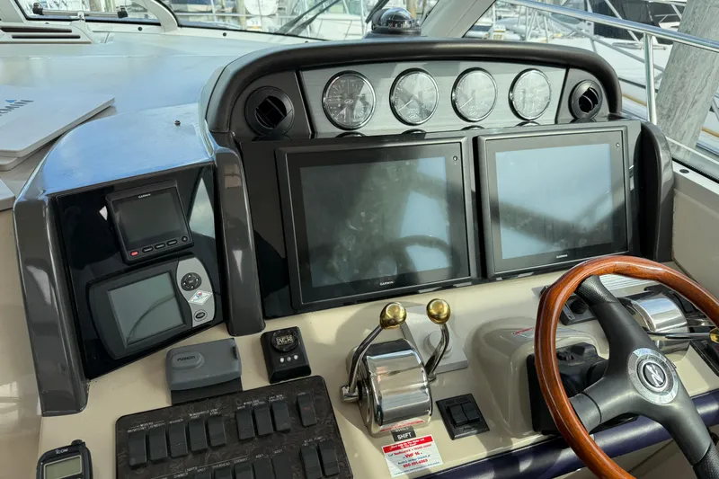 Turn The Page Yacht Photos Pics Helm of 2006 Sea Ray 48 Sundancer with dual screens and wooden steering wheel.