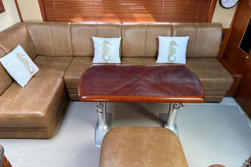 Turn The Page Yacht Photos Pics Luxurious 2006 Sea Ray 48 Sundancer interior with leather seating and elegant wooden table.