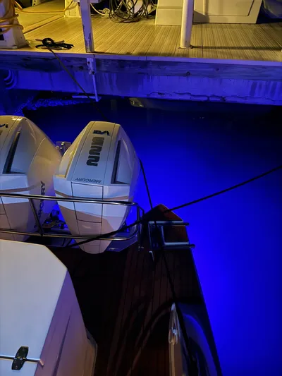  Yacht Photos Pics 2024 Hanover 305 boat with illuminated water and dual engines at a dock.