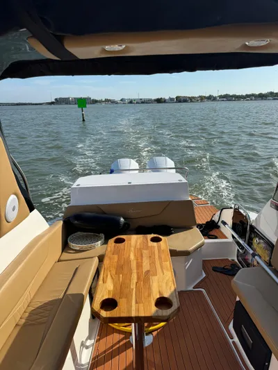  Yacht Photos Pics 2024 Hanover 305 boat interior with wooden table, cruising on open water.