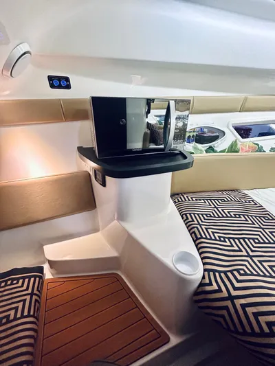  Yacht Photos Pics 2024 Hanover 305 interior with modern design, featuring cushions and wooden flooring.