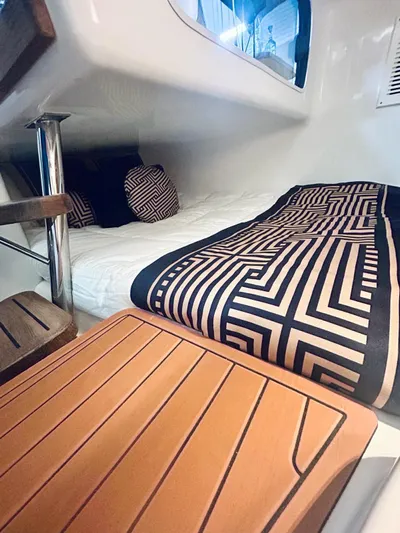  Yacht Photos Pics 2024 Hanover 305 cabin interior with geometric bedding and wooden accents.