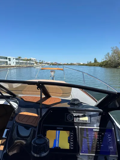  Yacht Photos Pics 2024 Hanover 305 boat navigating a serene river with clear blue skies.