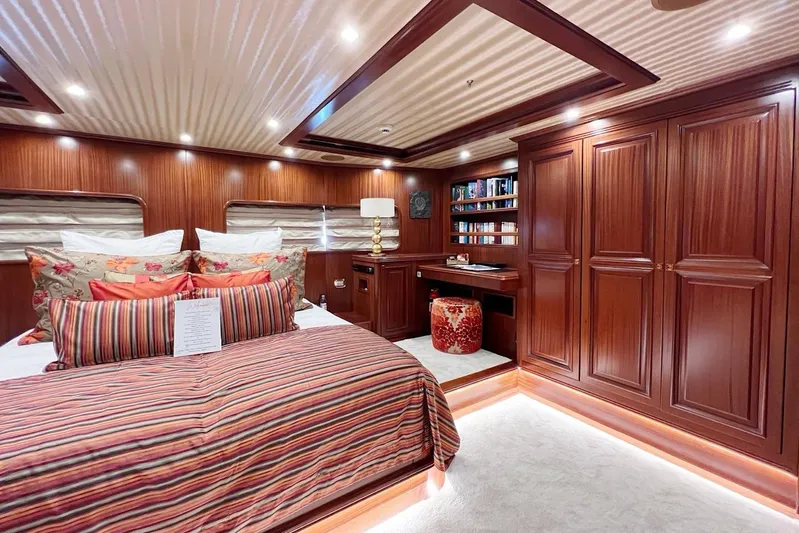  Yacht Photos Pics Luxurious yacht bedroom with wood paneling, striped bedding, and built-in shelves on Custom-Craft Steel Pax Navi 43 m.