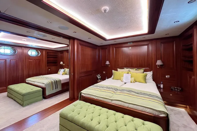  Yacht Photos Pics Luxurious yacht bedroom with wood paneling, green accents, and elegant lighting on Custom-Craft Steel Pax Navi.