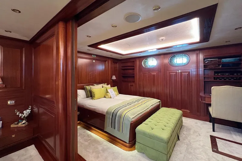  Yacht Photos Pics Luxurious yacht bedroom with wood paneling, elegant bedding, and ambient lighting on Custom-Craft Steel Pax Navi.