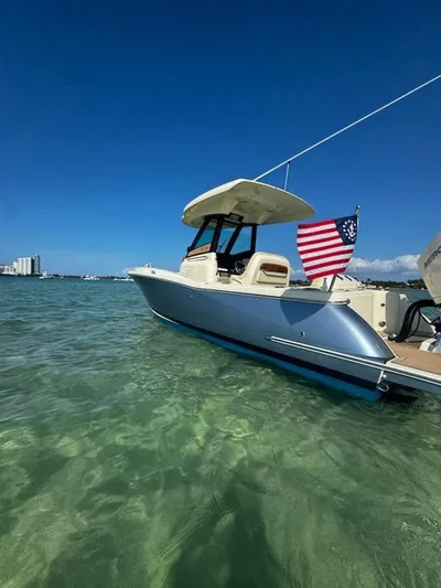  Yacht Photos Pics 2024 Chris-Craft Catalina 24 boat in clear water, American flag, sunny day.