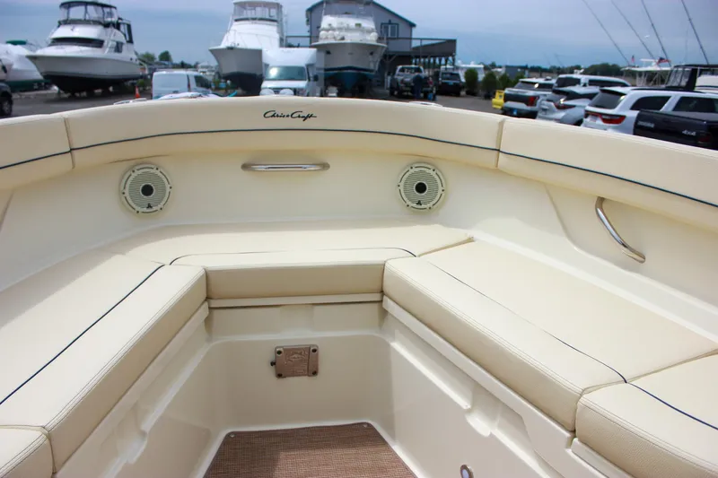  Yacht Photos Pics 2024 Chris-Craft Catalina 24 boat interior with beige seating and speakers, docked at a marina.
