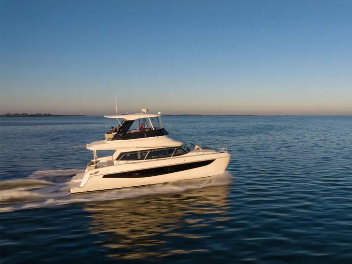 Superlux Yacht Photos Pics 2023 Aquila 42 Yacht cruising on calm ocean waters at sunset.