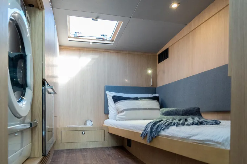 Superlux Yacht Photos Pics Modern cabin interior of 2023 Aquila 42 Yacht with bed and washing machine.