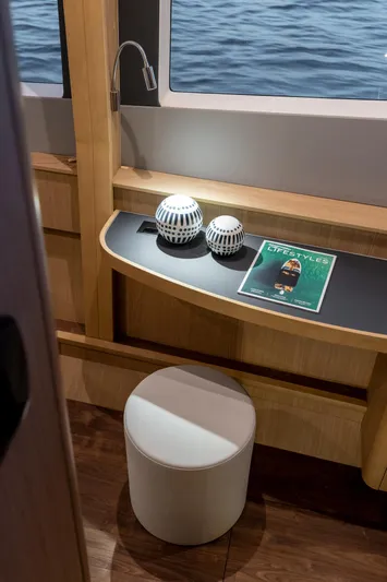 Superlux Yacht Photos Pics Interior of 2023 Aquila 42 Yacht with seating, table, and decorative items by a window.