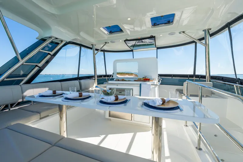 Superlux Yacht Photos Pics Luxurious interior of 2023 Aquila 42 Yacht with elegant dining setup and panoramic windows.