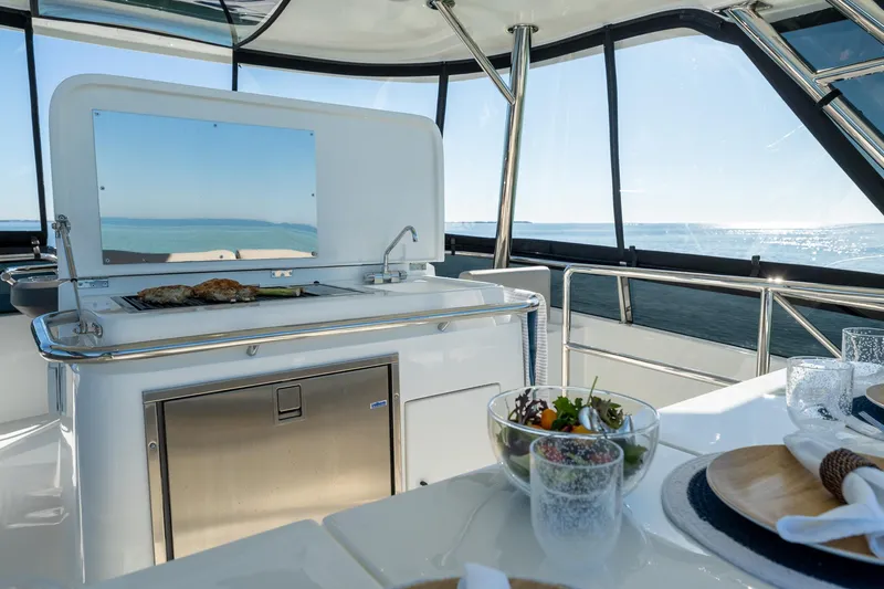 Superlux Yacht Photos Pics Luxurious 2023 Aquila 42 Yacht interior with dining setup and ocean view.