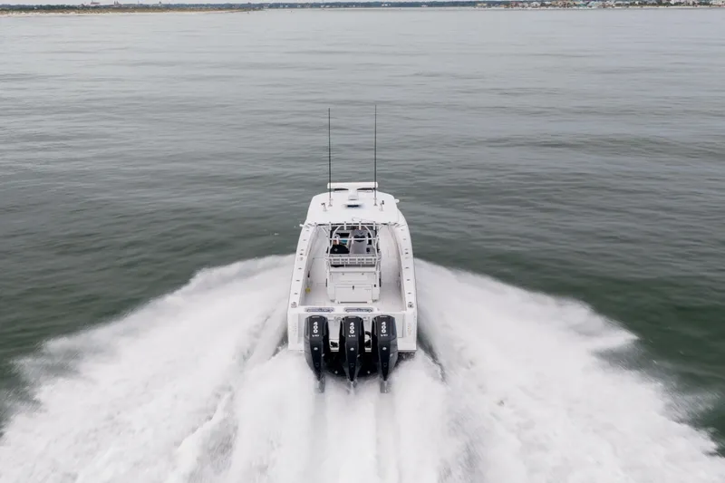  Yacht Photos Pics 2016 Contender 39 ST boat speeding on open water, rear view.