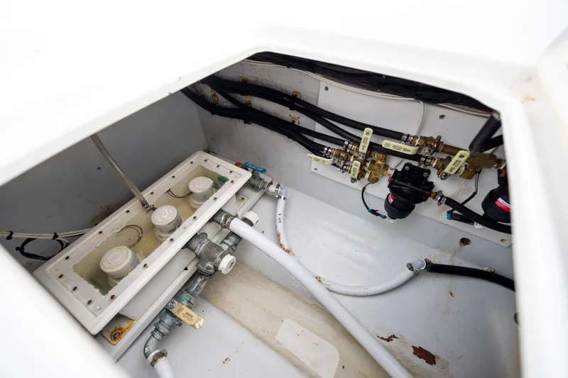  Yacht Photos Pics 2016 Contender 39 ST boat plumbing system with pipes and valves in a white compartment.