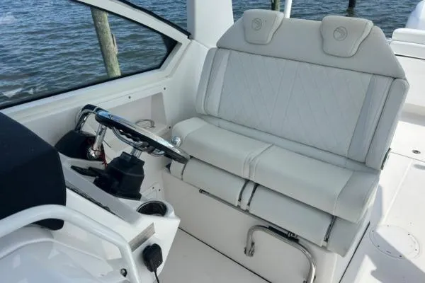 Little Mermaid Yacht Photos Pics 2019 Edgewater 262 CX boat interior with white seating and steering wheel.