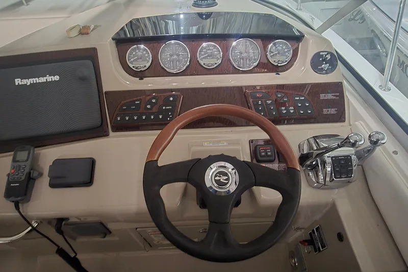 Lucky 13 Yacht Photos Pics 2009 Sea Ray Sundancer 350 helm with Raymarine navigation and wood-accented controls.