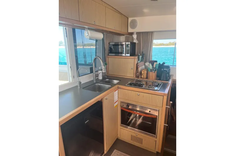 Cecil Yacht Photos Pics Interior of 2014 Lagoon 39 yacht kitchen with stove, sink, and ocean view.