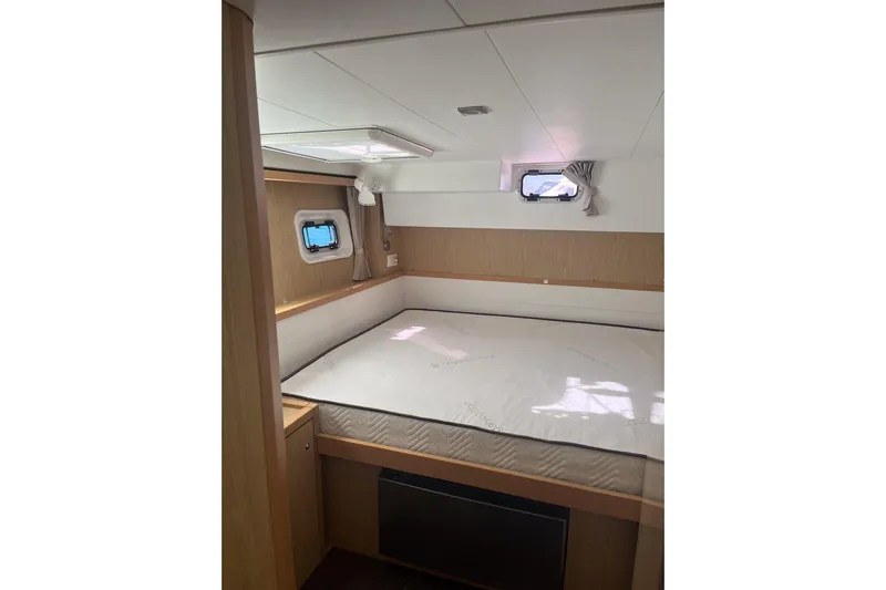 Cecil Yacht Photos Pics 2014 Lagoon 39 yacht cabin interior with bed, windows, and wooden accents.