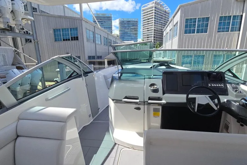  Yacht Photos Pics 2022 Aviara AV32 OB boat interior with modern helm and seating, docked near industrial buildings.