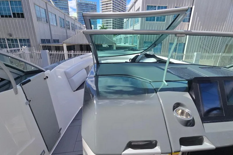  Yacht Photos Pics 2022 Aviara AV32 OB boat with sleek design and modern dashboard, docked near urban buildings.