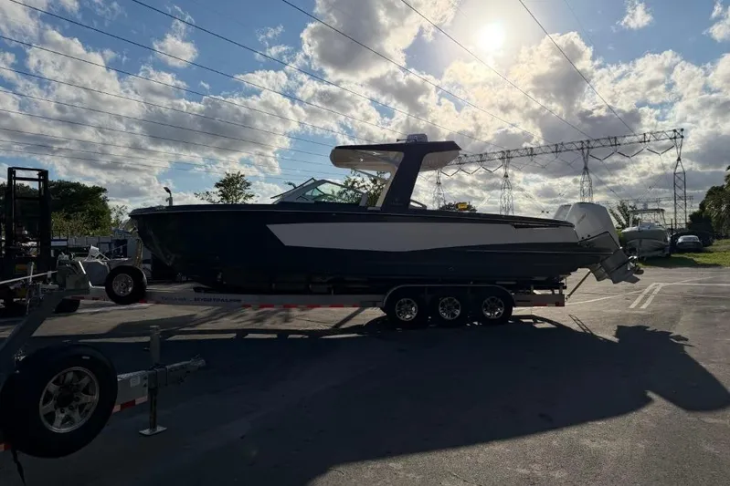  Yacht Photos Pics 2022 Aviara AV32 OB boat on trailer under a partly cloudy sky.