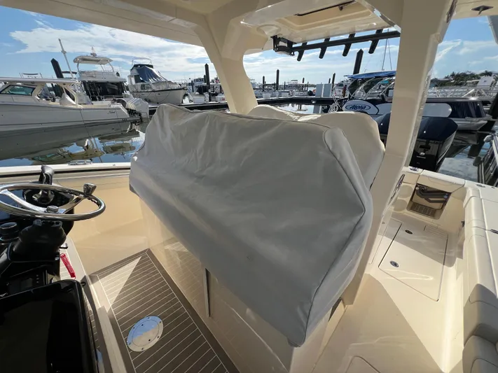 Yacht Photos Pics 2025 Scout 425 LXF boat interior with covered seating at a marina.