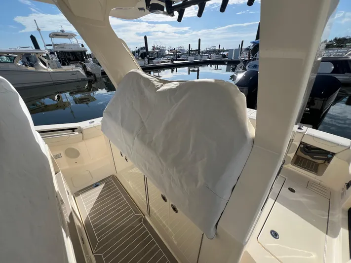  Yacht Photos Pics 2025 Scout 425 LXF boat interior at marina, showcasing sleek design and covered seating.