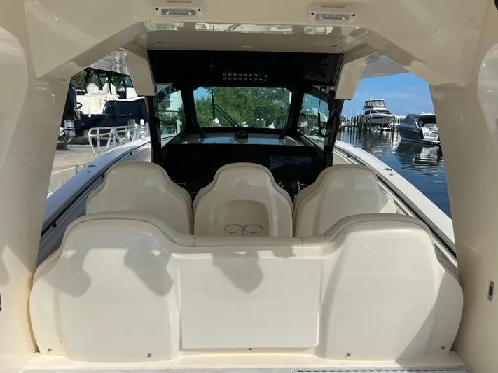  Yacht Photos Pics 2025 Scout 425 LXF boat interior with seating and helm, docked at marina.