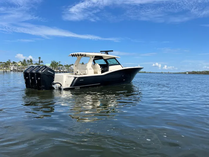  Yacht Photos Pics 2025 Scout 425 LXF boat on calm water under a clear blue sky.