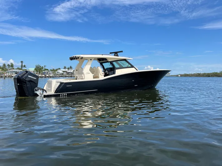  Yacht Photos Pics 2025 Scout 425 LXF boat on calm water under a clear blue sky.