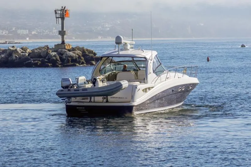 Hideout Yacht Photos Pics 2005 Sea Ray 390 Sundancer yacht cruising near rocky shoreline.