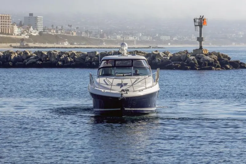 Hideout Yacht Photos Pics 2005 Sea Ray 390 Sundancer yacht cruising near rocky shoreline.