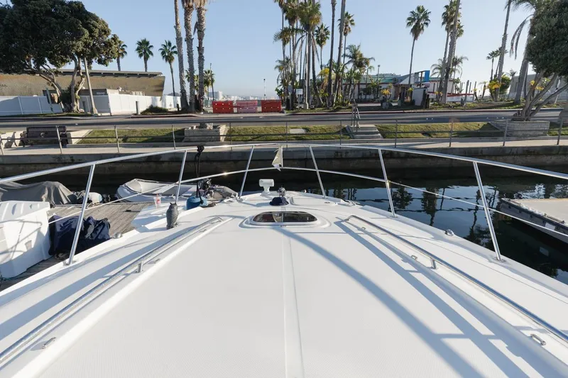 Hideout Yacht Photos Pics 2005 Sea Ray 390 Sundancer yacht docked near palm trees and waterfront.