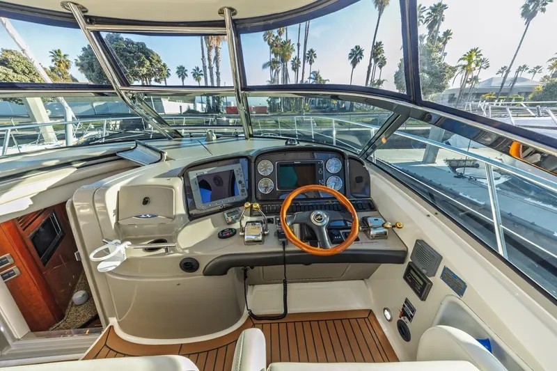 Hideout Yacht Photos Pics Helm of 2005 Sea Ray 390 Sundancer yacht with modern controls and wooden steering wheel.