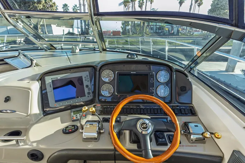 Hideout Yacht Photos Pics 2005 Sea Ray 390 Sundancer helm with modern navigation equipment and wooden steering wheel.