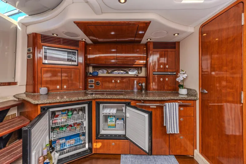 Hideout Yacht Photos Pics Luxurious 2005 Sea Ray 390 Sundancer yacht kitchen with wood cabinetry and open fridge.