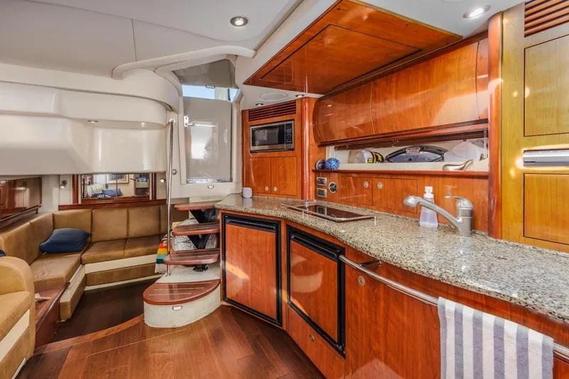 Hideout Yacht Photos Pics Luxurious 2005 Sea Ray 390 Sundancer yacht interior with modern kitchen and seating area.