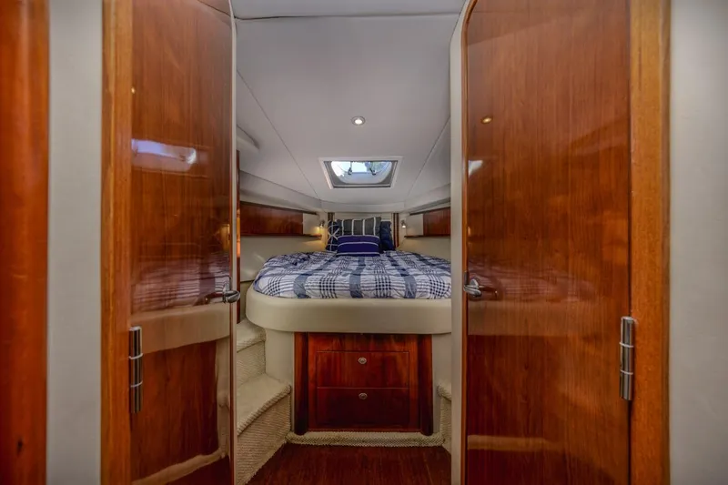 Hideout Yacht Photos Pics 2005 Sea Ray 390 Sundancer cabin interior with wood finish and cozy bed.