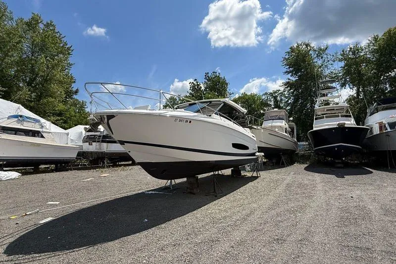  Yacht Photos Pics 2022 Regal 36 XO boat on dry dock, surrounded by other vessels, under a partly cloudy sky.