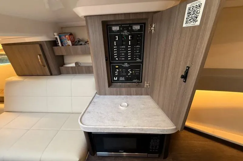  Yacht Photos Pics 2022 Regal 36 XO yacht interior with control panel, microwave, and seating area.