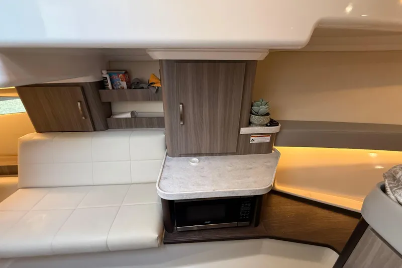  Yacht Photos Pics 2022 Regal 36 XO yacht interior with modern cabinetry, microwave, and seating area.
