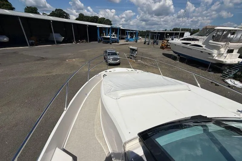  Yacht Photos Pics 2022 Regal 36 XO yacht in a marina with other boats and vehicles.